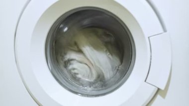 Çamaşır makinesi aile giysilerini temizliyor, ev rutini, elektrik israfı sahnesi. 4k