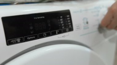 Ev hanımı, çamaşır yıkamak için modern çamaşır makinesi kullanıyor. Enerji tasarrufu.. 