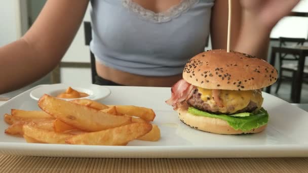 Vrouw Eet Hamburger Frietjes Een Fastfood Restaurant Ongezond Vet Voedsel — Stockvideo
