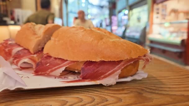 都市の食品市場レストランでジャモンセラーノハムサンドイッチのクローズアップビュー — ストック動画