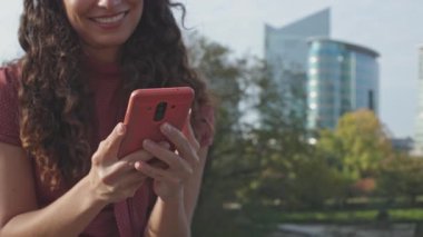 Cep telefonuyla el ele tutuşan ve yazan kadınlara yakın plan - arka planda fotokopi alanı ile gülen yüz