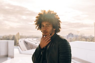 pride fashionable young african american cool man portrait with curly hair - warm daylight outside in city clipart