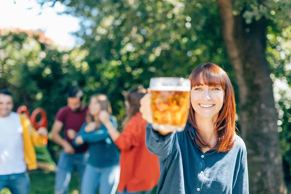 Partide Gülümseyen Kızıl Saçlı Genç Bir Bayan Bira Bardağıyla Tezahürat — Stok fotoğraf