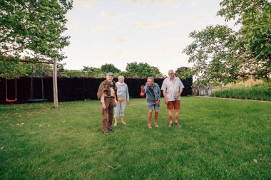Bir grup son sınıf öğrencisi parkta Petanque oynuyor.