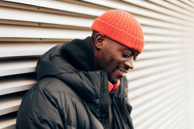 side view of smiling attractive cool hip-hop style young african man