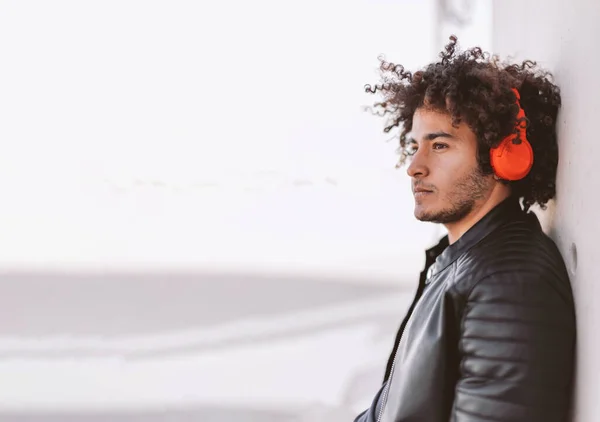 Casual Pensive Young Man Curly Hair Listening Audio Track Headphones Imágenes de stock libres de derechos