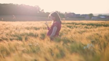 Rüzgarla savrulan buğday tarlasında yanan hamile bir kadın.