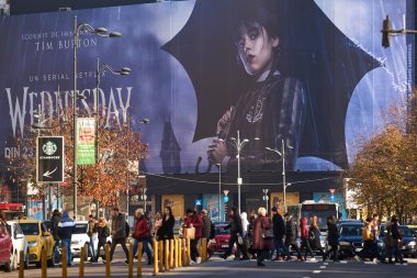 Bucharest, Romania - November 22, 2022: Extra large banner advertising Wednesday TV Series is displayed on the Unirea Shopping Center, in downtown Bucharest. This image is for editorial use only. clipart