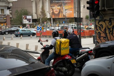 Bükreş, Romanya - 26 Ekim 2023: Bir Glovo gıda dağıtım kuryesi Romanya 'nın Bükreş kentinde gıda dağıtıyor.