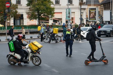 Bükreş, Romanya. 2 Kasım 2023: Glovo ve Bolt Food 'tan çanta taşıyan bir gıda kuryesi Bükreş şehir merkezindeki bir kavşaktan geçiyor.