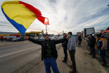 Afumati, Romanya - 15 Ocak 2024: Bükreş 'in 12 km kuzeyindeki Afumati komününde düzenlenen taşıma ve çiftçiler protestoları sırasında bir adam Romanya bayrağını dalgalandırdı.