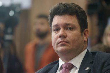 Bükreş, Romanya - 16 Şubat 2024: Devlet kuruluşu Nuclearelectrica 'nın CEO' su Cosmin Ghita, Enerji Bakanı Sebastian Burduja 'nın (resimde değil) bir basın toplantısında konuşmasını dinliyor