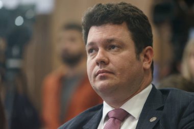 Bükreş, Romanya - 16 Şubat 2024: Devlet kuruluşu Nuclearelectrica 'nın CEO' su Cosmin Ghita, Enerji Bakanı Sebastian Burduja 'nın (resimde değil) bir basın toplantısında konuşmasını dinliyor