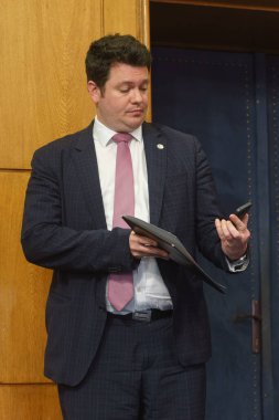 Bükreş, Romanya - 16 Şubat 2024: Devlet kuruluşu Nuclearelectrica 'nın CEO' su Cosmin Ghita, Enerji Bakanı Sebastian Burduja 'nın (resimde değil) bir basın toplantısında konuşmasını dinliyor