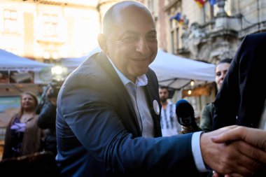 Bucharest, Romania. 29th Mar, 2024: Catalin Cirstoiu, the joint candidate for mayor of Bucharest of the Social Democratic Party (PSD) and the National Liberal Party (PNL), shake hands with a merchant The Agricultural Fair in the courtyard of the Mini clipart