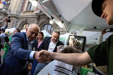 Bucharest, Romania. 29th Mar, 2024: Catalin Cirstoiu, the joint candidate for mayor of Bucharest of the Social Democratic Party (PSD) and the National Liberal Party (PNL), shake hands with a merchant The Agricultural Fair in the courtyard of the Mini clipart