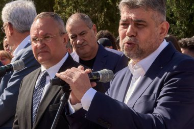 Bükreş, Romanya. 5 Nisan 2024: PSD genel başkanı Marcel Ciolacu (R), PSD PNL İttifakı aday listesinin Merkez Seçim Bürosu 'nda sunulması sonrasında düzenlediği basın toplantısında konuşma yaptı..