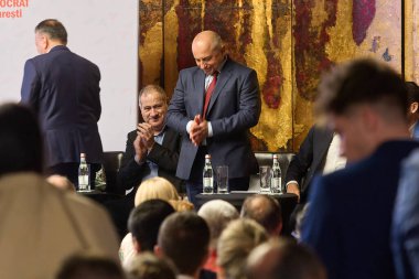 Bükreş, Romanya. 9 Nisan 2024: Sosyal Demokrat Parti (PSD) ve Ulusal Liberal Parti 'nin (PNL) Bükreş belediye başkanlığı ortak adayı Catalin Cirstoiu alkışlanırken tepki gösterdi