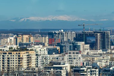 Bükreş, Romanya - 26 Mart 2024: Bükreş, Romanya - 26 Mart 2024: Bükreş 'in kuzeyindeki yüksek bir binanın yüksekliğinden görüldüğü üzere Bucegi Dağları.