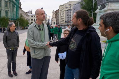 Bükreş, Romanya. 20 Nisan 2024: Eugen Hriscu (C-L), psikoterapist, psikiyatrist, bağımlılık tıbbı uzmanı, Rumen Pa tarafından oylanan yasalara aykırı olarak Bükreş 'teki Üniversite Meydanı' nda saat 16: 20 'de bir dakikalık flash mob' da katılımcıları karşıladı.