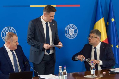 Bucharest, Romania. 23rd Apr, 2024: Marian Neacsu (L), Deputy Prime Minister of Romania, Mircea Abrudean (C), Secretary General of the Government, and Marcel Ciolacu (R), the Prime Minister of Romania, speak during the government meeting at the Victo clipart