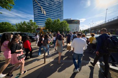 Bükreş, Romanya - 24 Mayıs 2024: İnsanlar Pipera semtinin kuzey ofis binalarında karşıdan karşıya geçiyorlar. Bu resim sadece editörler içindir..