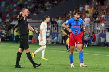 Bükreş, Romanya. 13 Ağustos 2024: FCSB 'den Risto Radunoviç (R), Steaua Stadyumu' nda FCSB ve AC Sparta Praha arasında oynanan UEFA Şampiyonlar Ligi (L) üçüncü ön eleme karşılaşmasında hakem Morten Krogh 'un (L) kararına tepki gösterdi.