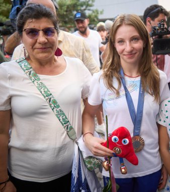 Bükreş, Romanya. 16 Ağustos 2024: Romen jimnastikçi Ana Maria Barbosu (R), Bükreş 'te düzenlenen törenin sonunda, yerde kazandığı Olimpiyat bronz madalyasıyla poz verdi. Barbosu madalyayı aldıktan birkaç hafta sonra aldı.