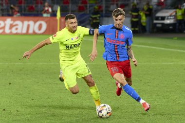 Bükreş, Romanya. 17 Ağustos 2024: FCSB 'den Octavian Popescu (R), FCSB ile Superliga' nın 6. turunda Politehnica Iasi arasında oynanan futbol karşılaşmasında Politehnica 'lı Mihai Bordeianu (L) karşısında top ile hareket halinde.