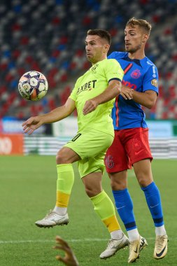 Bükreş, Romanya. 17 Ağustos 2024: Romanya Süper Ligi 'nin 6. turunda FCSB ile Politehnica Iasi arasında oynanan futbol karşılaşmasında Politehnica' dan Alin Roman (L) FCSB 'den Mihai Lixandru (R) top için mücadele etti.