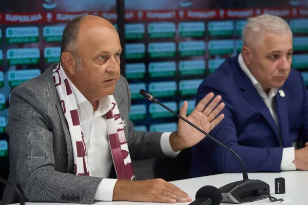 stock image Bucharest, Romania. 21st Aug, 2024: Dan Sucu (L), the financier of FC Rapid, speaks during the presentation of Marius Sumudica (R), the new coach of the Fotbal Club Rapid Bucharest, in a press conference, at Superbet Arena-Giulesti, in Bucharest.