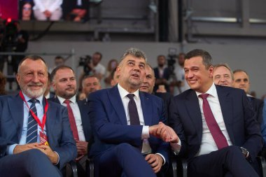Bükreş, Romanya. 22 Ağustos 2024: PSD genel başkanı ve Romanya başbakanı Marcel Ciolacu (C), PSD 'nin ilk genel başkan yardımcısı Sorin Grindeanu (R) tarafından ROMEXPO Sergisi' nde kutlandı.