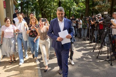 Bükreş, Romanya. 26 Ağustos 2024: Sosyal Demokrat Parti (PSD) genel başkanı Marcel Ciolacu ve Romanya başbakanı, PSD Ulusal Siyasi Bürosu 'nun Bükreş' teki genel merkezinde gerçekleşen toplantıdan sonra ayrıldılar.