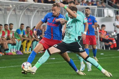 Bükreş, Romanya. 1. Sep, 2024: FCSB 'li Mihai Lixandru (L) Rumen 2024-2025 futbol şampiyonasının ilk ligi Superliga' nın 8. turunda FCSB ile UTA Arad arasında oynanan futbol karşılaşmasında Razvan (R) Trif of UTA ile top mücadelesi verdi.
