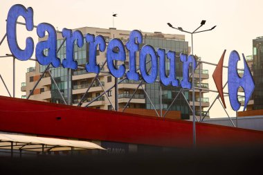 Bükreş, Romanya - 04 Eylül 2024: Fransız çokuluslu perakendecisi Carrefour 'un logosu Bükreş' teki Orhideea Alışveriş Merkezi 'ndeki dükkanının üzerinde görülüyor.
