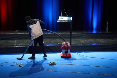 Bucharest, Romania. 25th Nov, 2024: A man cleans the stage where Elena Lasconi (not in Picture), Save Romania Union (USR) candidate for the president of Romania, will address her supporters after entering the presidential election runoff in second pl clipart