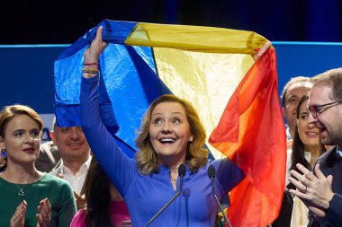 Bucharest, Romania. 25th Nov, 2024: Elena Lasconi, Save Romania Union (USR) candidate for the president of Romania, waves the Romanian flag at the end of her speech in front of her supporters after entering the presidential election runoff in second  clipart