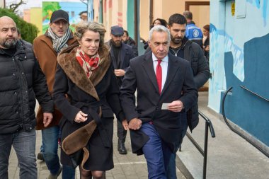 Mogosoaia, Romanya. 1 Aralık 2024: Romanya cumhurbaşkanlığı için aşırı sağ aşırı milliyetçi ikinci tur aday Calin Georgescu ve eşi Cristela, parlamento seçimleri için sandık merkezinde oy kullandıktan sonra ayrıldılar.