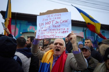 Mogosoaia, Romania. 8th Dec, 2024: A man shouts as far-right runoff candidate for presidency, Calin Georgescu, speaks to the press at a closed polling station after the elections were annulled. clipart