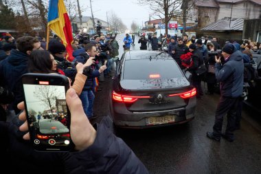 Mogosoaia, Romanya. 8 Aralık 2024: Romanya cumhurbaşkanlığı ikinci tur adayı Calin Georgescu (C), seçimlerin yasal olarak geçersiz sayılmasının ardından kapalı bir sandık merkezinden ayrıldı.