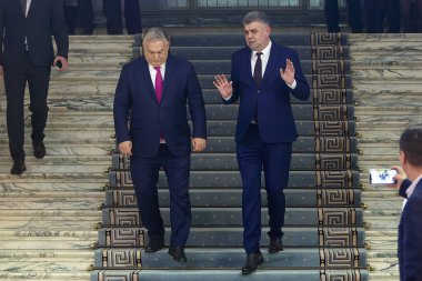 Bükreş, Romanya. 20 Aralık 2024: Macaristan Başbakanı Viktor Orban (L), Romanya Başbakanı Marcel Ciolacu 'yu (R) resmi görüşme sonrasında dinliyor.