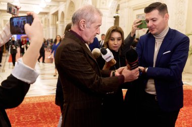 Bükreş, Romanya. 20 Aralık 2024: Romanya Birliği İttifak Vekili George Becali (L), münasebetsiz bulduğu sorulara yanıt olarak bir gazeteciden mikrofonu aldı..