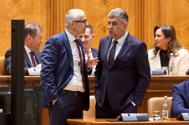 Bükreş, Romanya. 5 Şubat 2025: Adalet Bakanı Radu Marinescu (L), 2005 Bütçe Tartışması sırasında Romanya Başbakanı Marcel Ciolacu (R) ile konuştu.