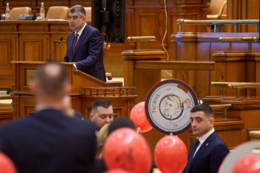 Bükreş, Romanya. 28 Şubat 2025: AUR milletvekilleri hükümete karşı yapılan güven oylamasında Başbakan Marcel Ciolacu 'yu (sol üstte) Pinokyo olarak tasvir eden pankartlarla protesto ettiler.