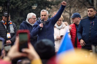 Bükreş, Romanya. 1. Mar, 2025: Aşırı sağ aşırı milliyetçi Calin Georgescu (C), Marcel Ciolacu liderliğindeki hükümete karşı düzenlenen Romen Birliği (AUR) mitinginde katılımcılara seslendi.