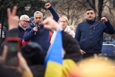 Bükreş, Romanya. 1. Mar, 2025: Aşırı sağ aşırı milliyetçi Calin Georgescu (L), Marcel Ciolacu liderliğindeki hükümete karşı düzenlenen Romen Birliği için İttifak (AUR) mitinginde katılımcılara seslendi.