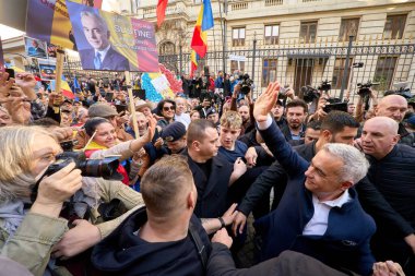 Bükreş, Romanya. 7. Mar, 2025: Aşırı milliyetçi Calin Georgescu, 2025 Romanya cumhurbaşkanlığı seçimlerine aday ve eşi Cristela, Merkez Seçim Bürosu 'nda destekçileri selamlıyor.