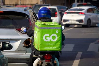Bükreş, Romanya, 22. Mar 2025: GO 'nun GO dağıtımında GO Sharing ve gıda dağıtım kuryesi Romanya' nın Bükreş kentinde gıda dağıtımı yapıyor.
