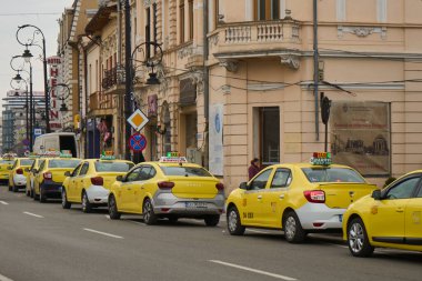 Craiova, Romanya. 28. Mar, 2025: Dolj County 'nin Craiova kentinin girişindeki Alexandru Ioan Cuza Caddesi' ndeki bir taksi durağında sarı taksiler park halinde..