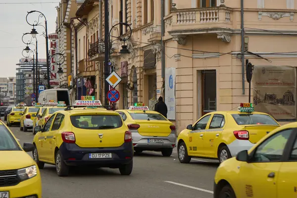 Craiova, Romanya. 28. Mar, 2025: Dolj County 'nin Craiova kentinin girişindeki Alexandru Ioan Cuza Caddesi' ndeki bir taksi durağında sarı taksiler park halinde..